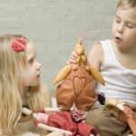 A girl and boy play with soft toys