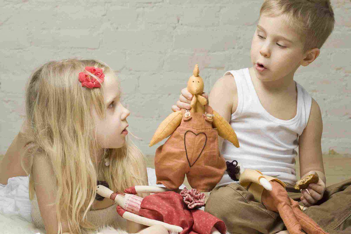 A girl and boy play with soft toys