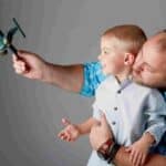 A man and boy play with a toy aeroplane