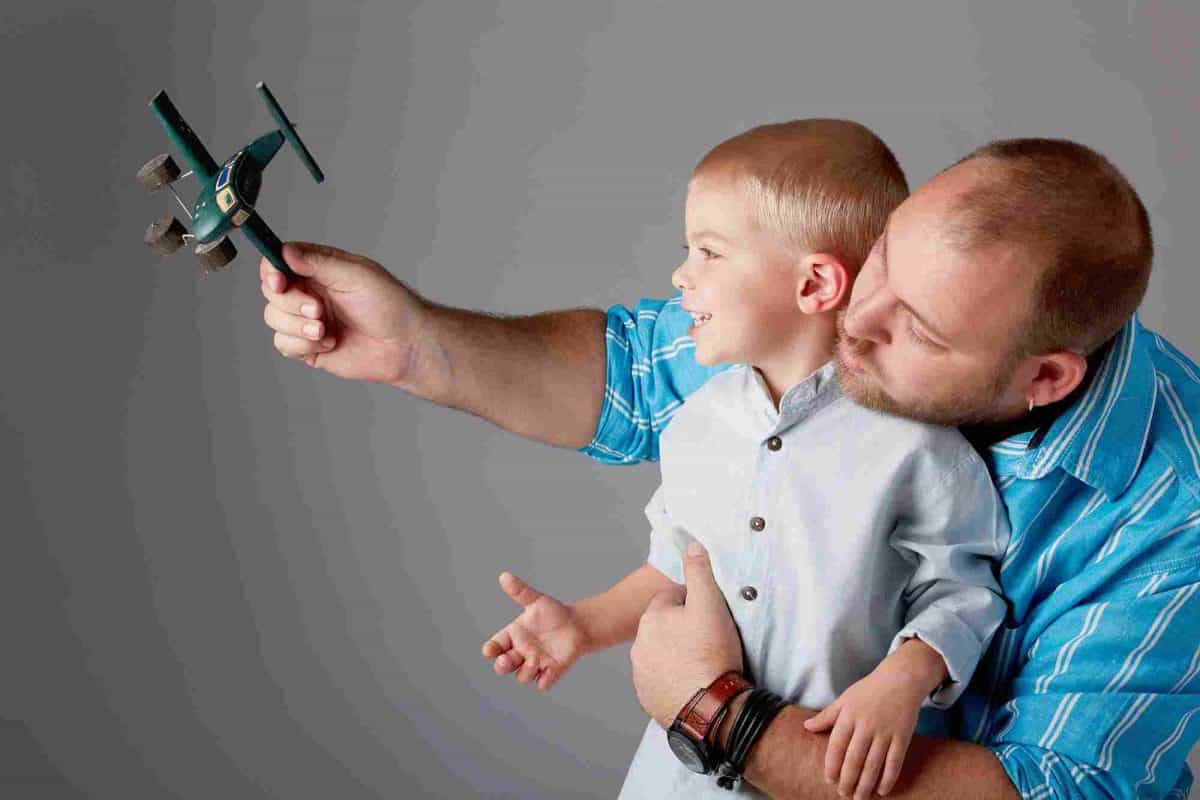 A man and boy play with a toy aeroplane
